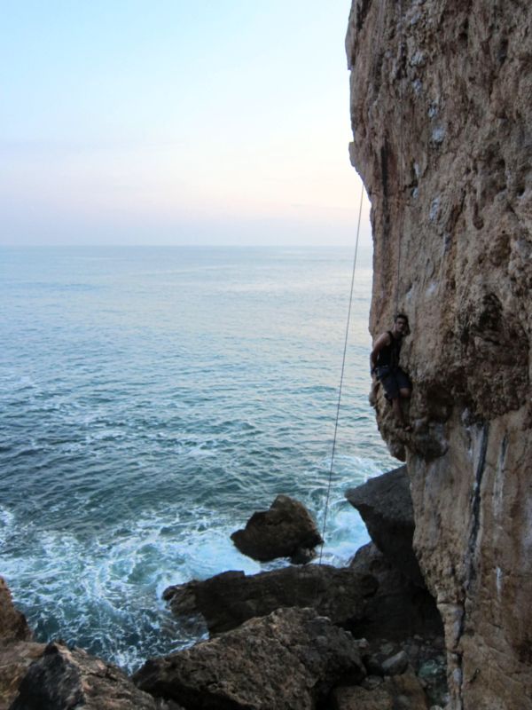 Альпинист со страховкой на берегу океана у Кашкая. ( Португалия.  Фото Лимарева В.Н.) 